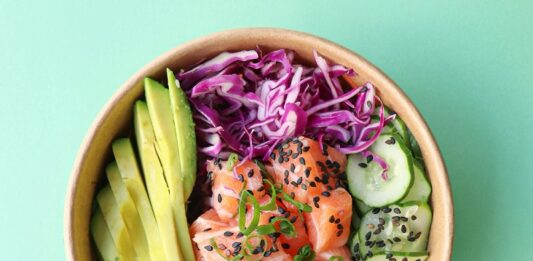 Ensalada con aguacate, salmón, fruta y verdura variada