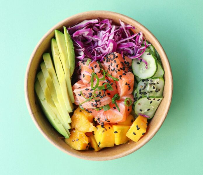 Ensalada con aguacate, salmón, fruta y verdura variada