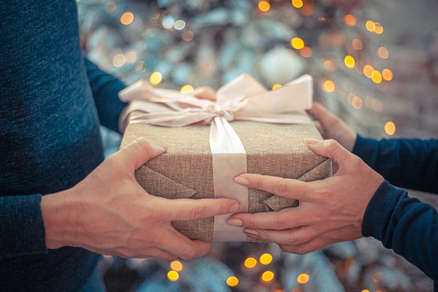 Una caja, manos y regalos en navidad